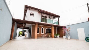 Una casa a due piani con un balcone, una bicicletta e piante in vaso.