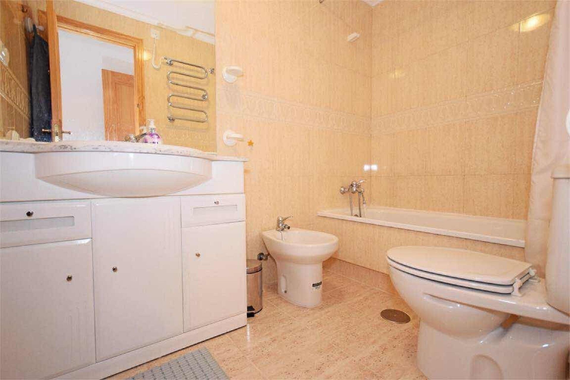 A bathroom with a sink, bidet, toilet, and bathtub.