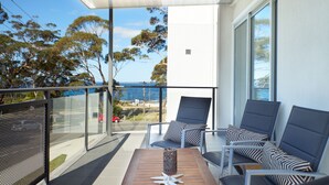 Ein Balkon mit Blick aufs Meer, zwei Liegestühle, ein Tisch und ein dekorativer Seestern.