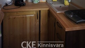Une cuisine compacte dotée de meubles en bois, d’un four à micro-ondes, d’une machine à café et d’une cuisinière.