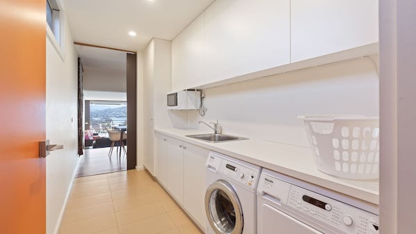 Uma cozinha moderna com máquina de lavar embutida, micro-ondas e pia.