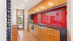 Une cuisine moderne avec des meubles en bois, un évier en acier inoxydable et un lave-vaisselle.