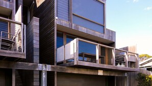 Un immeuble moderne à plusieurs étages, doté de balcons et de grandes fenêtres.