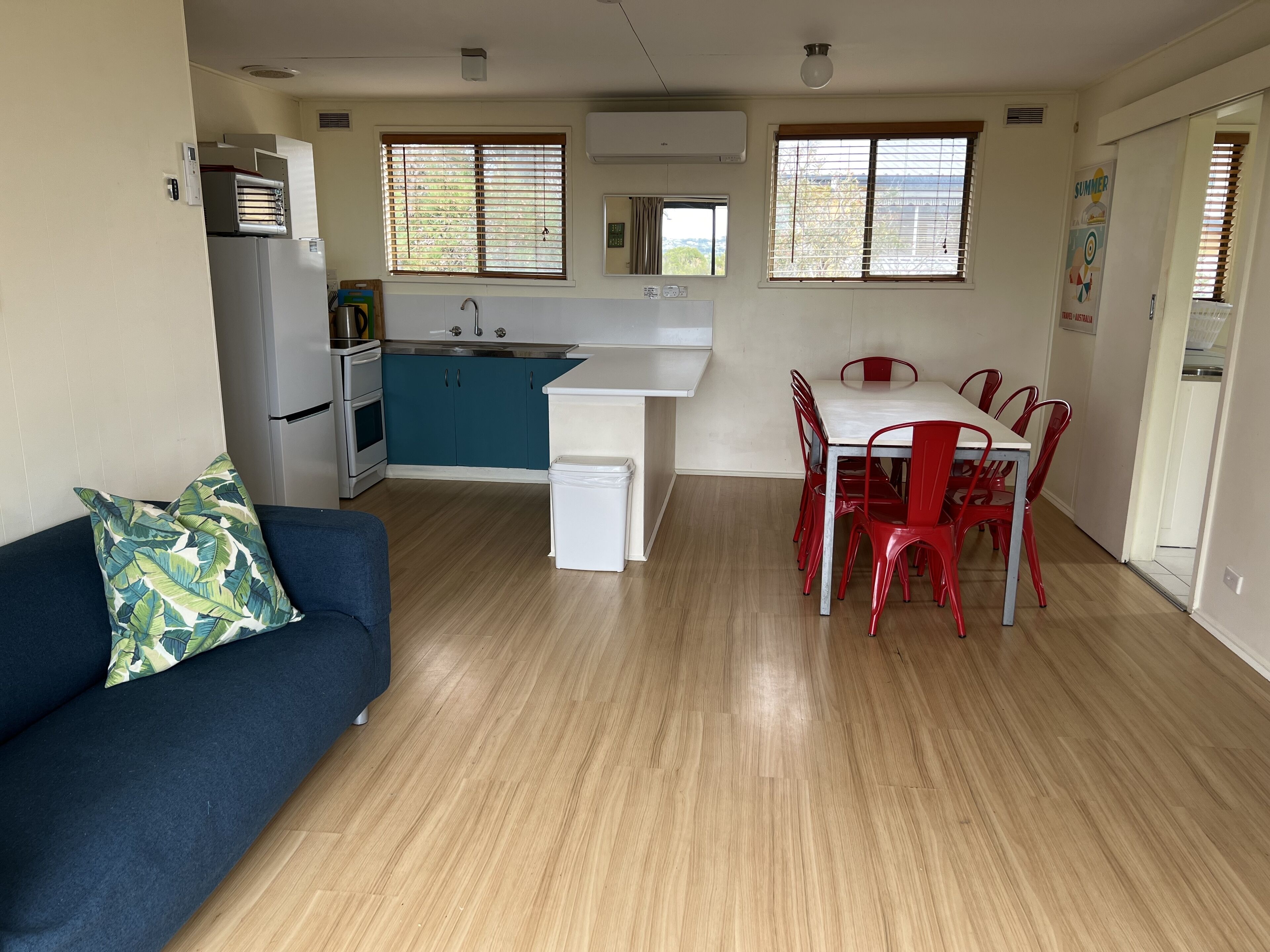 Una cocina compacta con un lavamanos, estufa y un comedor con mesa y sillas.