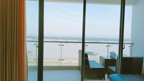 Enjoy a serene view of the water from the balcony with a table and chairs.