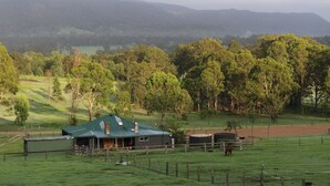 A rural house with a green roof, surrounded by a fenced pasture and trees. - Newly Renovated with aircon throughout! Family, Horse and Dog Friendly Getaway (Congewai)