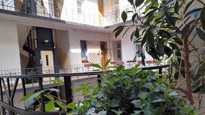 Un edificio de varios pisos con balcones, una escalera y vista de la calle.