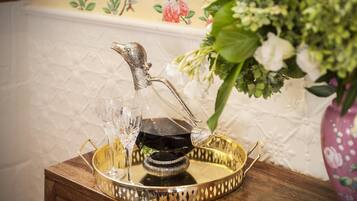 A tray with a decorative pitcher and glasses on a wooden table.