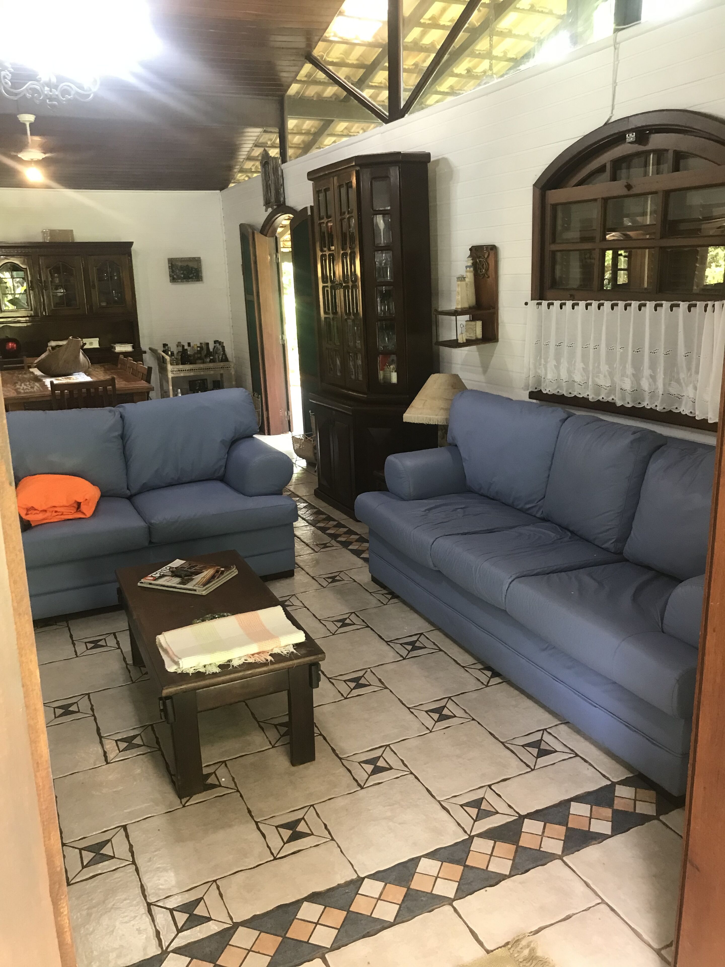 Una sala de estar con dos sofás azules, una mesa de centro y un suelo estampado.