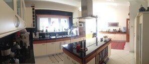 Una cocina moderna con armarios blancos, encimera negra y alfombra roja.