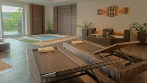 A modern indoor pool area with lounge chairs, a hot tub, and a sofa. - PRIVATE Family VILLA with jakuzzi & swimming pool (Budaörs)