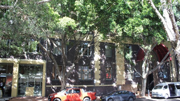 A building with a brick facade, large windows, and a tree in front. - Harbourside Comfort and Charm (Pyrmont)