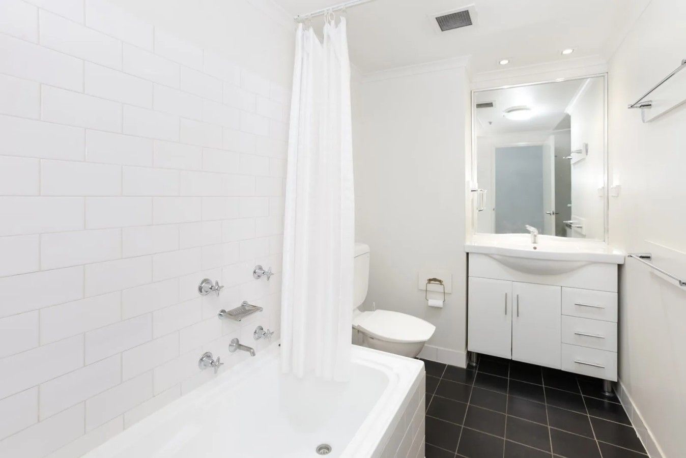 A modern bathroom with a bathtub, toilet, and sink.