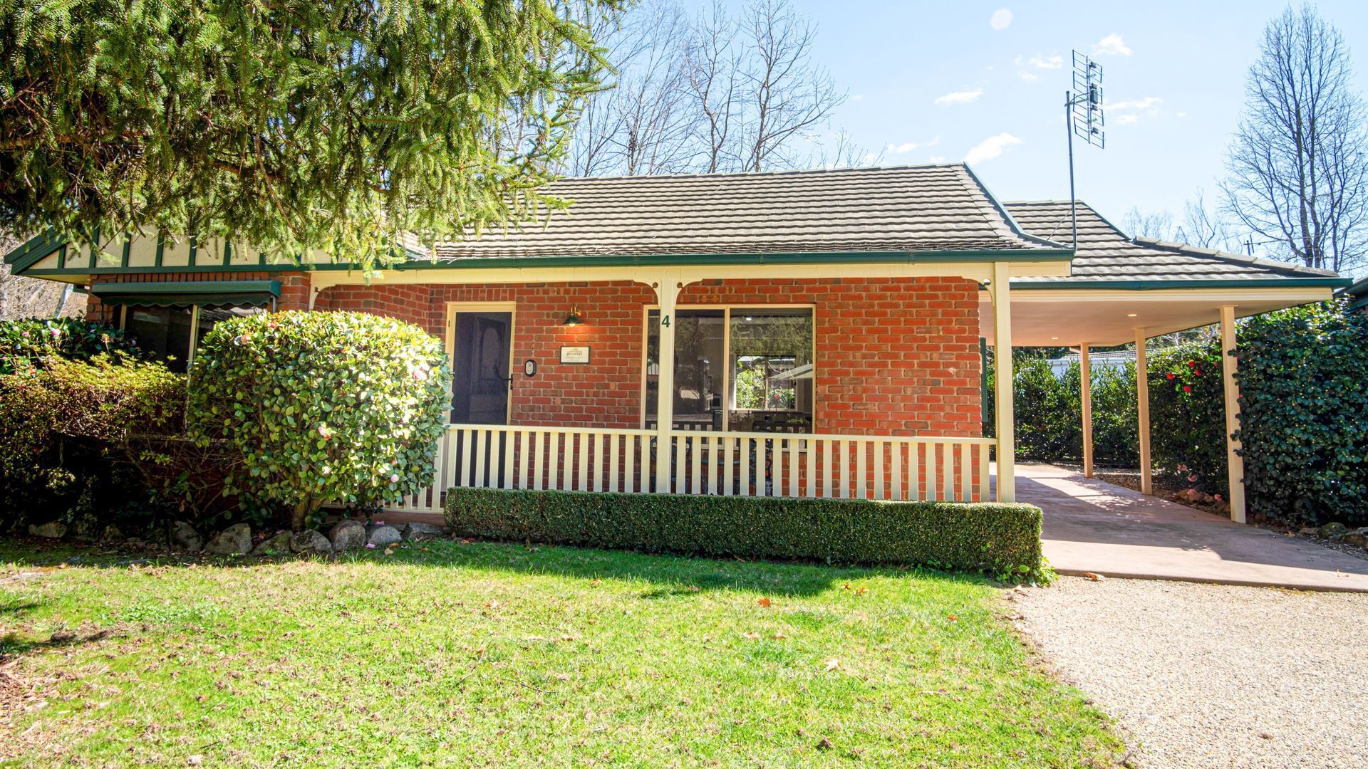 A small brick building with a covered porch, a door, and a window.