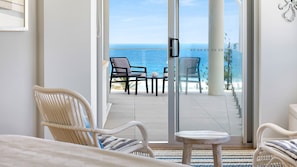 Enjoy ocean views from the balcony with a seating area and sliding glass door.