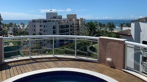 A rooftop pool with a view of the ocean and buildings.