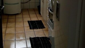 Eine kleine Küche mit Kühlschrank, Spüle und Fenster.