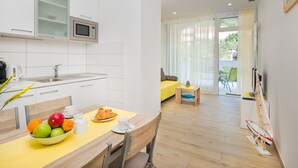 Une cuisine moderne équipée d’un four à micro-ondes, d’un évier et d’un coin repas avec une table mise pour le petit-déjeuner.