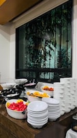 A buffet setup with various dishes and stacked plates.