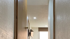 A wooden staircase leading to a room with a desk and chair, a framed picture on the wall, and a window with blinds. - Hotel San Lucas (Mexico City)