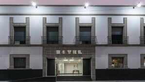 A hotel facade with a clear entrance, multiple windows, and a balcony on the upper floor. - Hotel San Lucas (Mexico City)