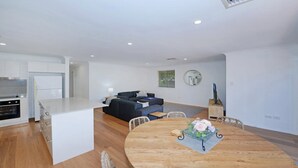 A modern apartment with a kitchen, dining area, and living room.