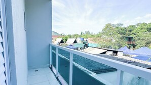 A balcony with a view of a green building and trees. - House for vacation in Maranduba/Ubatuba (Maranduba)