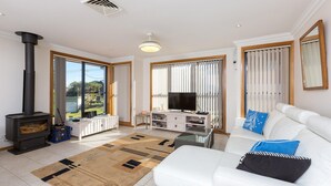 Een moderne woonkamer met een open haard, een televisie en een bank.