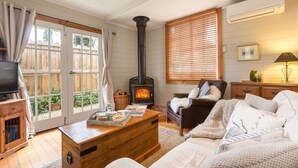 Ein gemütliches Wohnzimmer mit Kamin, Holzmöbeln und einem Fernseher.