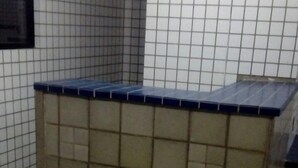 Une cuisine carrelée avec un plan de travail bleu et un pare-feu en carreaux.