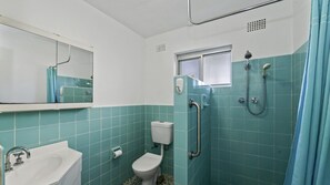 A bathroom with a toilet, sink, and shower. - Avoca Beachfront - South Strand 4 (Avoca Beach)