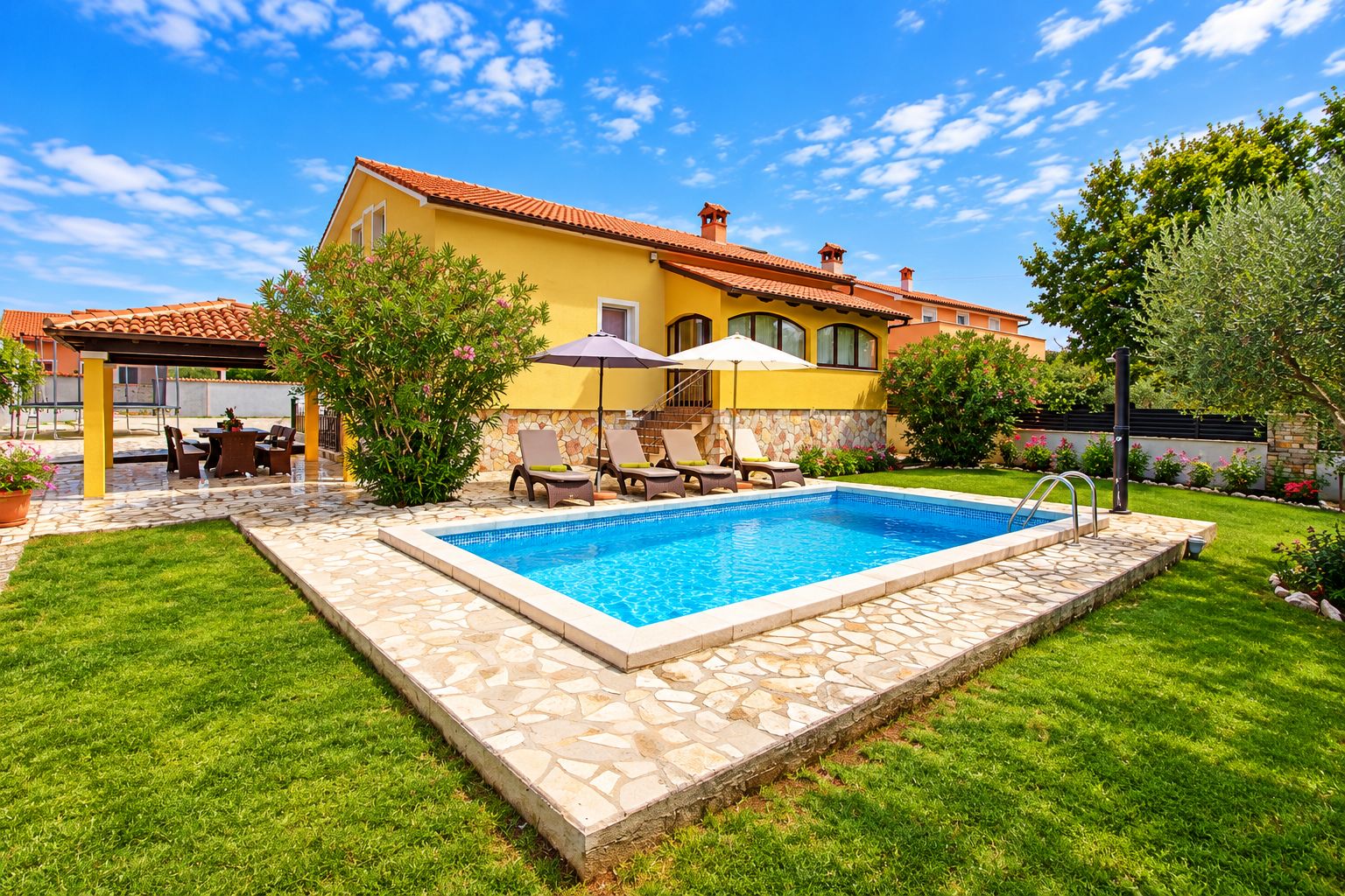Um imóvel residencial com piscina, área de estar externa e um jardim bem cuidado.
