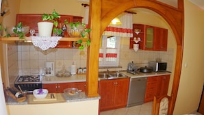 Cucina con mobili in legno, fornello, lavello ed una lavastoviglie.