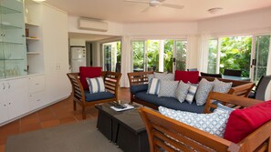 A spacious living area with a sofa set, a dining table, and a kitchen area.