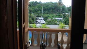 Un balcon donnant sur un quartier résidentiel, avec vue sur les maisons et la végétation.