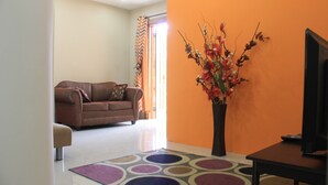Un salon avec un canapé marron, une table basse et un vase décoratif contenant des fleurs.