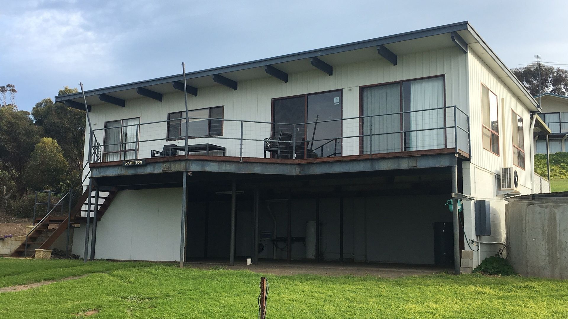 A two-story building with a balcony and a covered patio area.