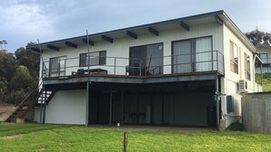 Un edificio de dos pisos con un balcón y un patio cubierto.