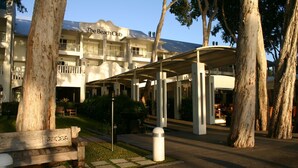 The Beach Club with a covered outdoor area, large trees, and a wooden bench. - Ground floor, Poolside Luxury Apartment (Palm Cove)