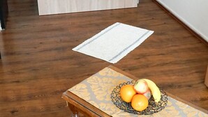 Een slaapkamer met een bed, een nachtkastje met een lamp, een stoel en een tafel met fruit.