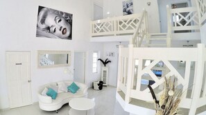 Relax in this stylish space with a curved sofa, round table, and framed picture on the wall.