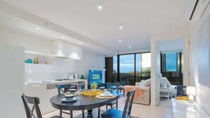 Un espace de vie moderne comprenant un coin repas, une cuisine et un salon avec vue.
