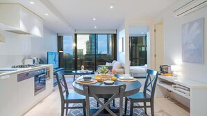 Une cuisine moderne avec un coin repas, de grandes fenêtres et une vue sur la ville.