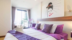A hotel room with a large bed, a view of the outdoors, and a wall decoration. - Romantic Honeymoon Siam Suite, Central Chiang Mai (Tambon Chang Khlan)