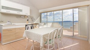 A modern kitchen with a dining area, large windows, and a view of the sea. - Holiday House Botta With Pool (Seaside Near Split) (Marušici)