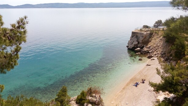 A coastal view with clear water, a sandy beach, and rocky cliffs. - Holiday House Botta With Pool (Seaside Near Split) (Marušici)