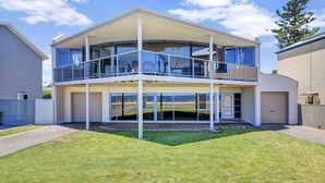 A two-story house with a balcony, large windows, and a garage. - Sail Away - Aldinga Beach - C21 SouthCoast Holidays (Aldinga Beach)
