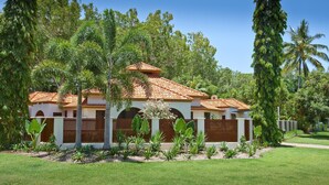 A two-story building with a tiled roof, surrounded by lush greenery and palm trees. - 7 Solander Boulevard, Port Douglas QLD 4877 (Port Douglas)