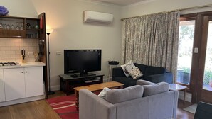 A modern living room with a grey sofa, a flat-screen TV, a wooden coffee table, and a red rug. - Ideal location to explore historic Strathalbyn, Wineries, good food and scenery (Strathalbyn)