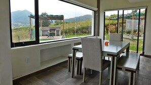 Un espace de restauration moderne offrant une vue sur un vignoble grâce à de grandes fenêtres.